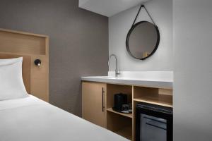 a bathroom with a bed and a sink and a mirror at Radisson Hotel Cedar Rapids in Cedar Rapids