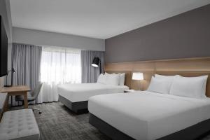 a hotel room with two beds and a window at Radisson Hotel Cedar Rapids in Cedar Rapids