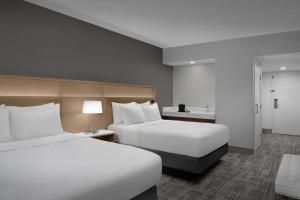 a hotel room with two beds and a table and lamp at Radisson Hotel Cedar Rapids in Cedar Rapids +79 photos