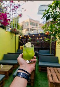 a person holding a green drink in their hand at Boho Boutique Hotel Amman in Amman