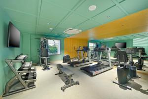 a gym with several tread machines and a flat screen tv at Ginger Hyderabad Genome Valley in Turkapally +15 photos
