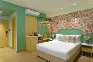 a bedroom with a white bed and a green wall at Ginger Hyderabad Genome Valley in Turkapally