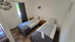 a small bedroom with two beds and a ottoman at Bella Ciao in Badacsonytomaj