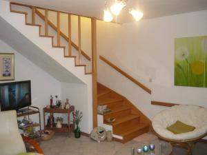 ein Wohnzimmer mit einer Treppe mit einer Couch und einem Fernseher in der Unterkunft Apartments Luka in Sevid