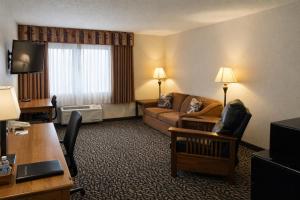 a hotel room with a couch and a living room at Fireside Inn and Suites in Devils Lake