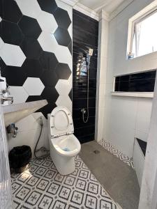 a bathroom with a toilet and black and white tiles at Villas Transient Inn in San Juan +10 photos