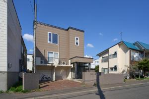 a house on a city street with buildings at Sapporo Vacation Home B&B in Sapporo