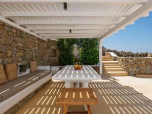 a white pergola with a table on a patio at Aqua Lumen Private Pool Villa, Mykonos in Agios Ioannis Mykonos