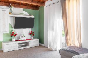 a bedroom with a tv and a bed and a window at Jungle Holiday Apartment in Avola