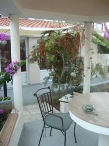 eine Terrasse mit einem Tisch, einem Stuhl und Blumen in der Unterkunft Apartments Luka in Sevid + 50 Fotos