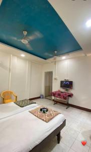 a bedroom with two beds and a blue ceiling at MUKTAI LODGE in Solapur