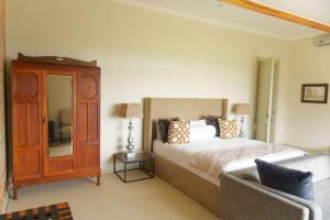 a bedroom with a bed and a mirror and a chair at Highveldt Farm, Nottingham Road in Fort Nottingham +173 photos