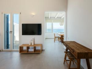 a living room with a television and a table at Aqua Lumen Private Pool Villa, Mykonos in Agios Ioannis Mykonos