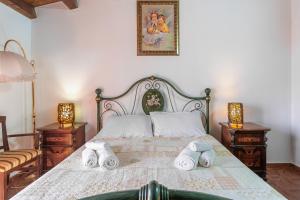 a bedroom with a bed with towels on it at Jungle Holiday Apartment in Avola