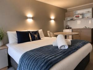 a bedroom with a large bed and a table at High Plains Lodge Rooms in Dinner Plain