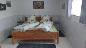 a small bedroom with a wooden bed with two pillows at Mühlbachhof in Berg