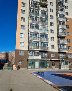 a large apartment building with a bench in front of it at Undraa's cosy small apt in Ulaanbaatar