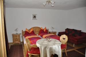 ロイタッシュにあるStöffelhofのベッドルーム1室(カラフルな枕とテーブル付きのベッド1台付)