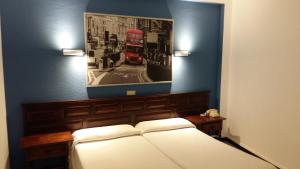 a bedroom with a bed and a picture of a red bus at Hotel Tejuma in Puerto de la Cruz