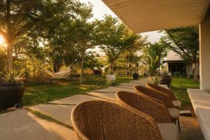 a row of wicker chairs sitting on a sidewalk at Art Hill Villas in Kao Kuil