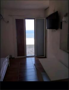 a room with a door to a balcony with a view of the ocean at Waves of Millos in Skopelos Town