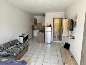 a living room with a couch and a kitchen at Waves of Millos in Skopelos Town