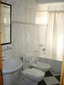 a bathroom with a sink and a toilet and a tub at Hotel Guillermo II in Mazarrón