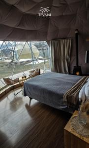 a bedroom with a bed and a large window at Tevani Glamping in Gyulagarak