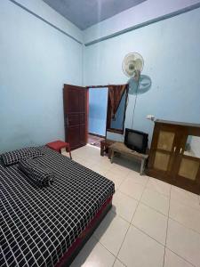 a bedroom with a bed and a fan at EXPRESS O 91669 Kost Amel Near Taman Mattirotasi in Parepare