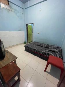 a bedroom with a bed and a table and a bench at EXPRESS O 91669 Kost Amel Near Taman Mattirotasi in Parepare