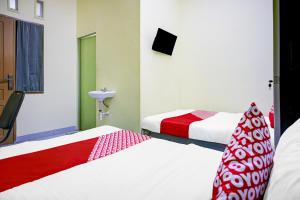 a hotel room with two beds and a sink at Hotel O Balige City Near Tugu Juara Monang in Balige