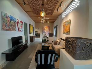 a living room with a couch and a tv at Art Hill Villas in Kao Kuil