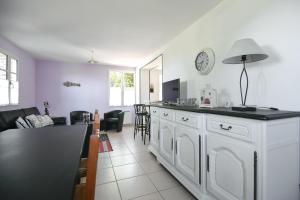 a kitchen and living room with a counter and a table at Gîte Lilas de mer in Ponthoile