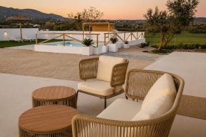 a patio with wicker chairs and tables and a pool at Casa rural Doble-R in Ronda