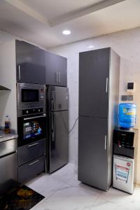 a kitchen with a stainless steel refrigerator and a microwave at Lekki Abijo Apartment in Lekki