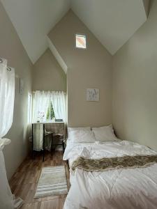 a bedroom with a bed and a table and a window at silverpine khao kho in Phetchabun