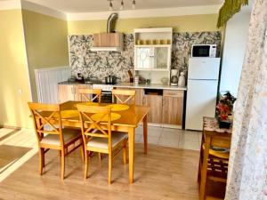 a kitchen with a yellow table and chairs and a refrigerator at Vormsi ohvitseride maja korter nr 7 in Hullo