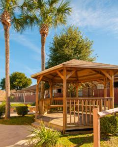 un gazebo in legno in un parco con palme di Executive Inn a Pensacola