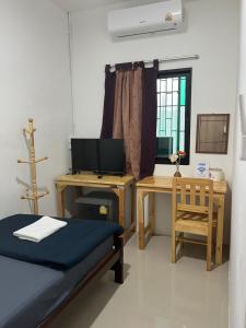a room with a bed and a desk with a computer at SDD HoSTEL in Thung Si Kan