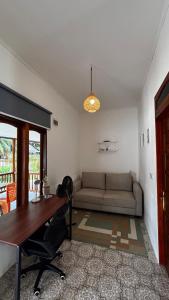 a living room with a desk and a couch at Anugerah's House in Katiet