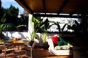 un patio con sofá, mesa y algunas plantas en Botanic Home, en Marbella