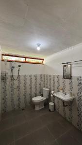 a bathroom with a toilet and a sink at Anugerah's House in Katiet