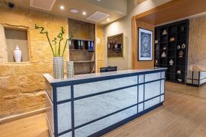 a lobby with a stone wall and a reception counter at The Vincent Boutique Hotel, BW Premier Collection in Valletta +258 photos