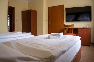 a hotel room with two beds and a tv at Hotel Rudka in Kunštát +12 photos
