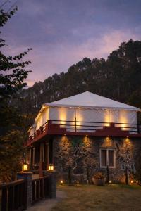 a building with a tent on top of it at night at The Stone Hamlet Retreat in Barkot +7 photos