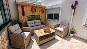 a patio with wicker furniture and a table and chairs at L'ALGA in Càbras