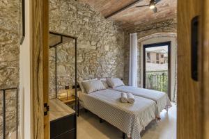 a bedroom with a bed and a stone wall at El Corral in Agullana