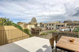 a balcony with a wooden table and a view of a city at El Corral in Agullana
