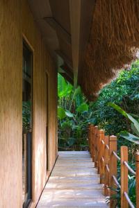 a wooden walkway outside of a building with trees at Ma'oni Seascape Villas in Panglao Island