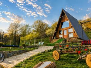 a log cabin with a wheelbarrow in front of it at Căsuța de pe Vale in Sighetu Marmaţiei